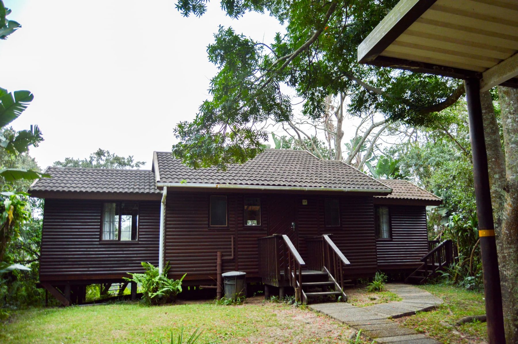 Deluxe Chalet exterior with timber steps among leafy trees